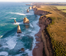 Aerial photo of the Twelve Apostles and coastline on a sunny day.