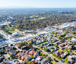 Aerial photo of a transport infrastructure building site and surrounding houses and parkland in Melbourne.