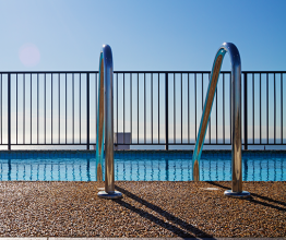 Image of swimming pool edge with ladder. Photo courtesy of Jodie Johnson/Shutterstock.com