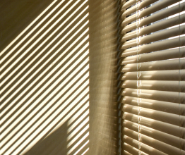 Shadows cast onto a wall by venetian blinds.