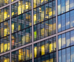 Exterior face of an office building with illuminated windows.