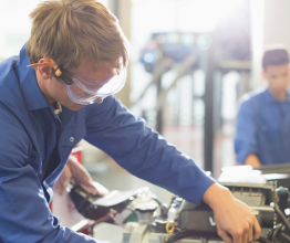 An engineering student working on an engine in a TAFE workshop.