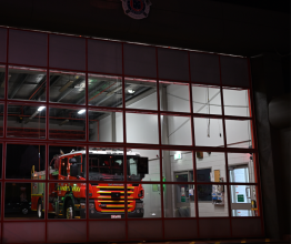 A fire truck inside a fire station at night.